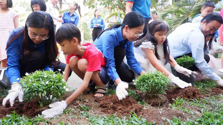 Các đại biểu cùng trồng cây với các bạn nhỏ trong khuôn viên sân chơi thiếu nhi tại cụm chung cư An Lộc - An Phúc (TP Thủ Đức, TP.HCM) - Ảnh: K.ANH