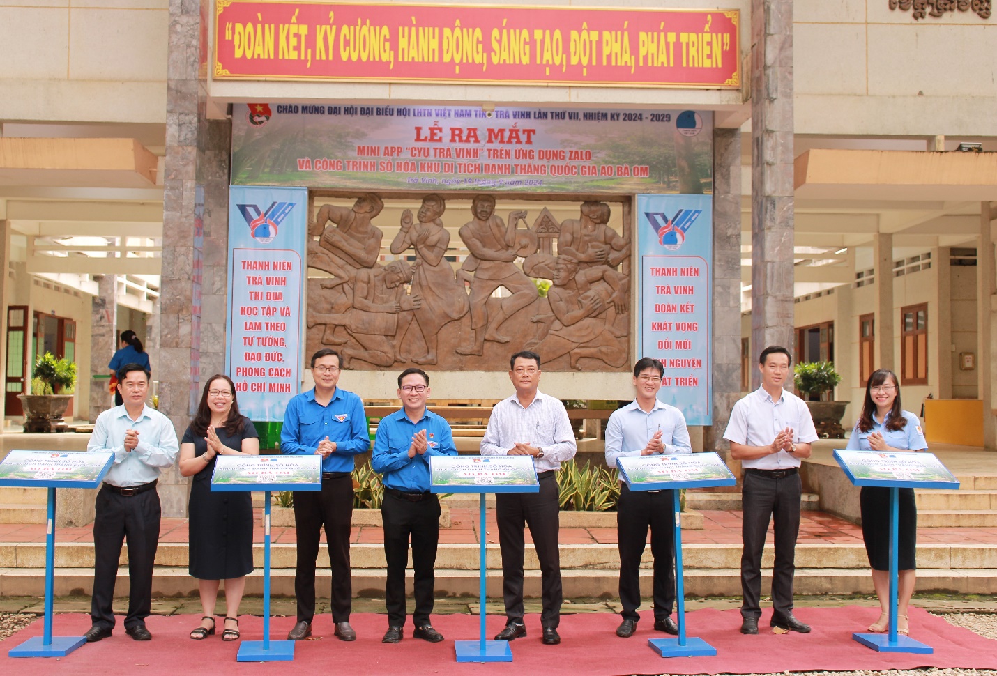 A group of people standing in front of a building Description automatically generated