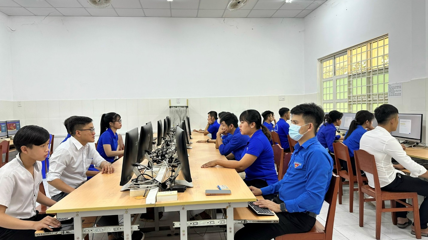 A group of people in a room with computers

Description automatically generated